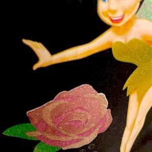 Disney’s tinker Bell, tote bag in black with Tinker Bell bent over a shiny rose.